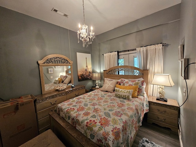 bedroom with dark hardwood / wood-style floors and a notable chandelier