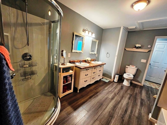 bathroom with vanity, toilet, hardwood / wood-style floors, and a shower with shower door