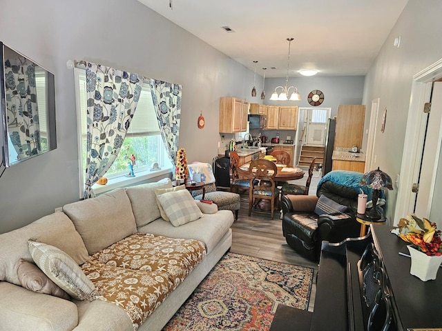 living room with sink, light wood-type flooring, and a notable chandelier