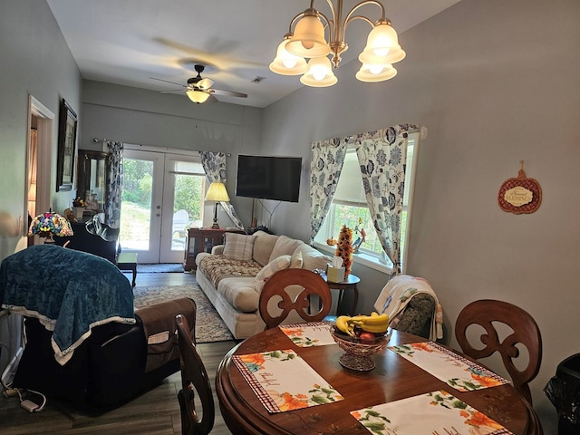 dining area with hardwood / wood-style floors, ceiling fan with notable chandelier, and french doors