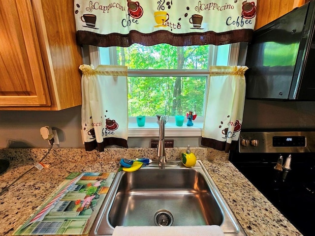 kitchen with sink, light stone countertops, and stainless steel electric range oven