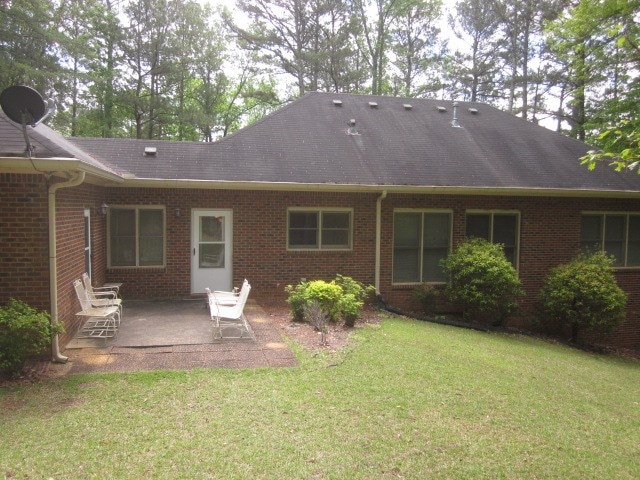 629 Camp Branch Rd, Ellijay, GA 30540 - back of house featuring a patio, brick siding, a lawn, and a shingled roof