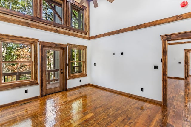 spare room with ceiling fan, a high ceiling, and hardwood / wood-style flooring