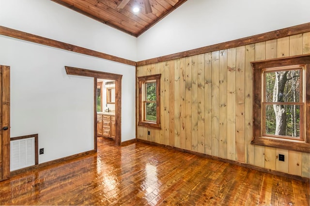 empty room with ceiling fan, high vaulted ceiling, dark hardwood / wood-style floors, wood walls, and wood ceiling