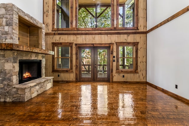 unfurnished living room featuring a fireplace, a high ceiling, and plenty of natural light