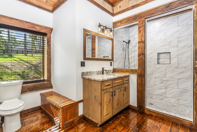 bathroom with toilet, vanity, and tiled shower