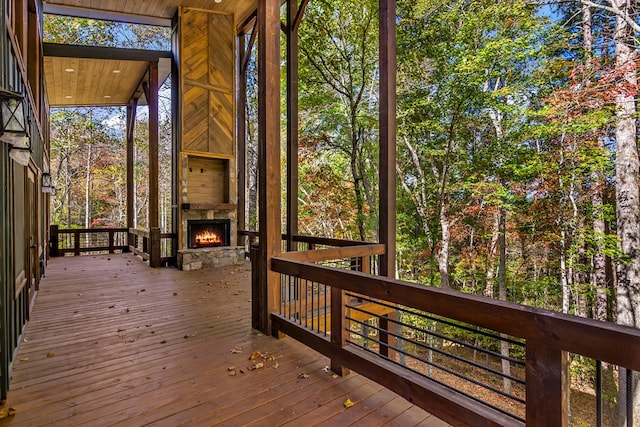 deck with an outdoor stone fireplace