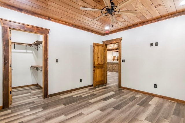 spare room with ceiling fan, wood-type flooring, wooden ceiling, and crown molding