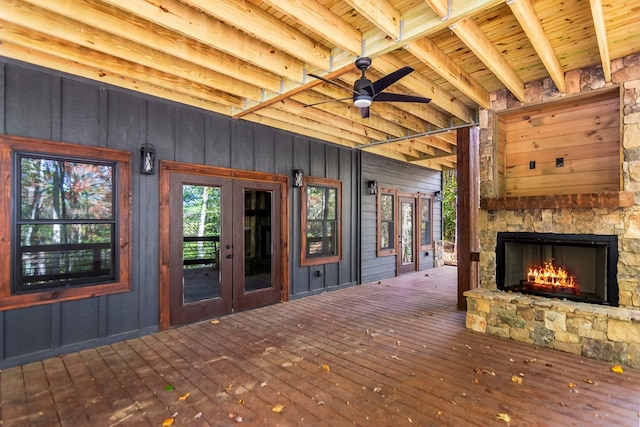 wooden terrace featuring ceiling fan, a fireplace, and french doors