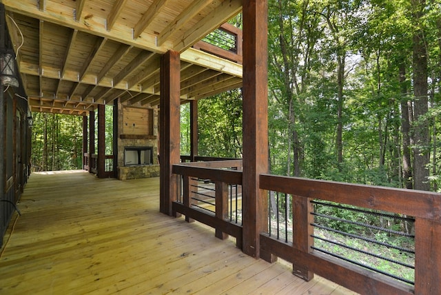 wooden deck with an outdoor stone fireplace