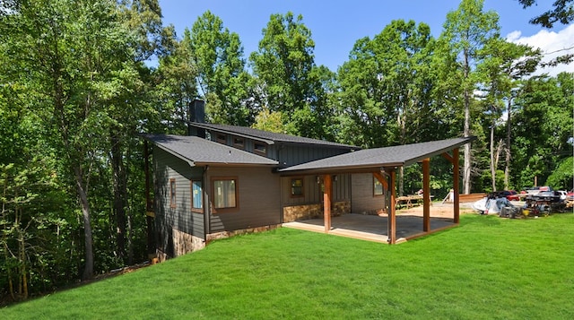 back of house featuring a lawn and a patio area