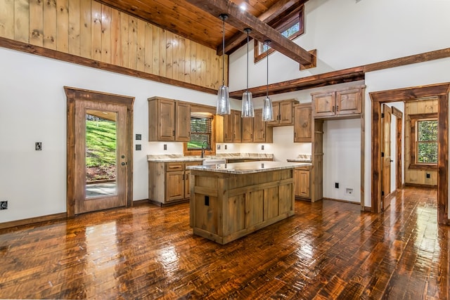 kitchen featuring beam ceiling, a center island, high vaulted ceiling, and plenty of natural light