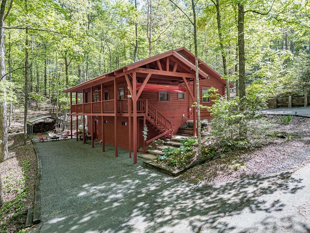 view of outbuilding featuring stairs and a forest view