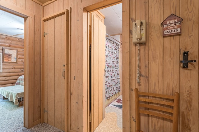corridor with carpet flooring and rustic walls
