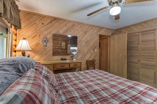 bedroom with a closet, ceiling fan, and wooden walls