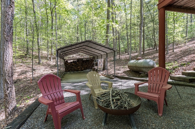 view of patio / terrace featuring a detached carport and a wooded view