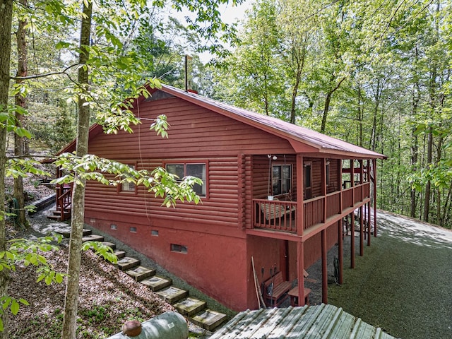 view of side of property with stairway and crawl space