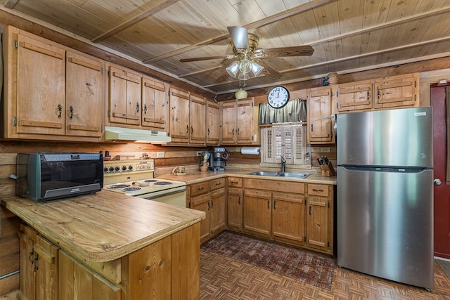 kitchen featuring electric range, a sink, light countertops, freestanding refrigerator, and under cabinet range hood