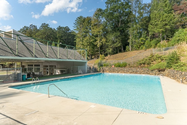 pool with fence and a patio area
