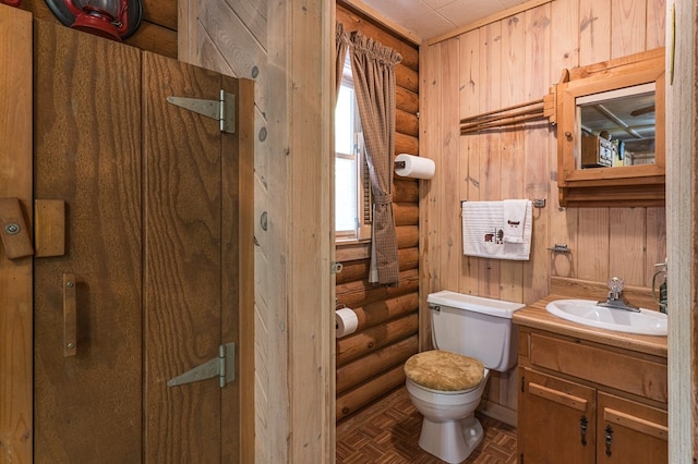 bathroom featuring log walls, vanity, and toilet