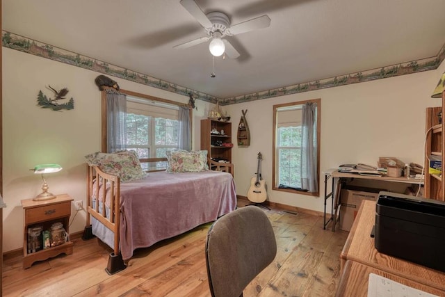 bedroom with light wood-type flooring, multiple windows, and ceiling fan