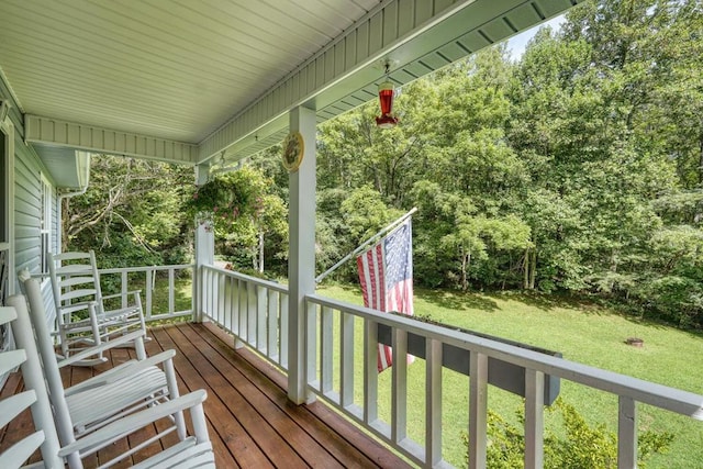 wooden terrace featuring a lawn