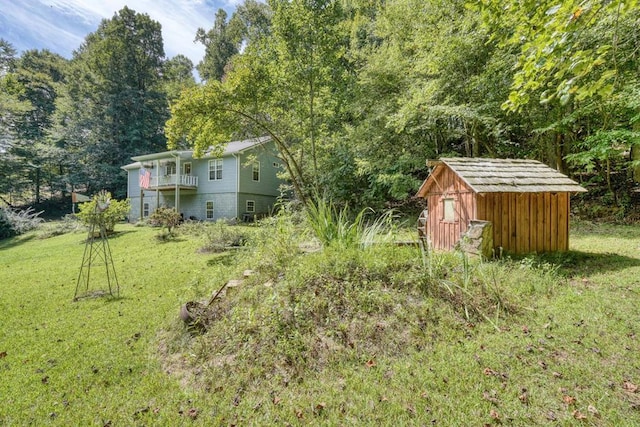 view of yard with a balcony and a storage shed