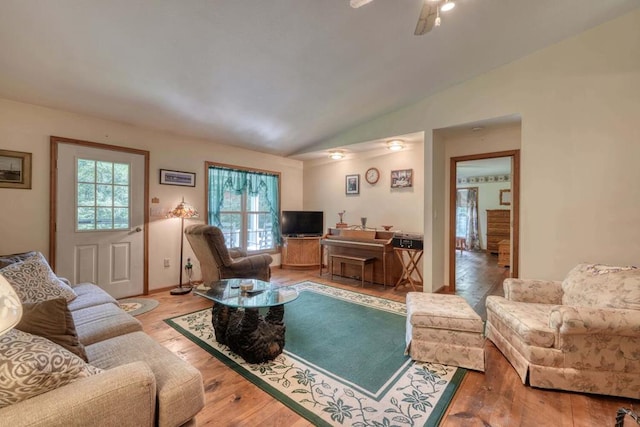 living room featuring light hardwood / wood-style flooring, vaulted ceiling, and ceiling fan