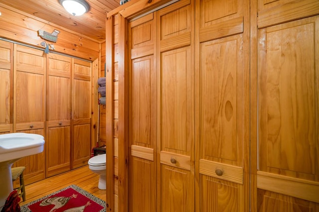 bathroom featuring hardwood / wood-style flooring, toilet, and wooden ceiling