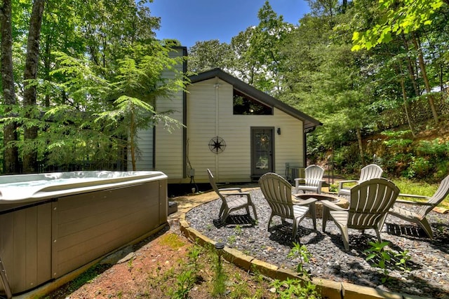 exterior space with an outdoor fire pit and a hot tub