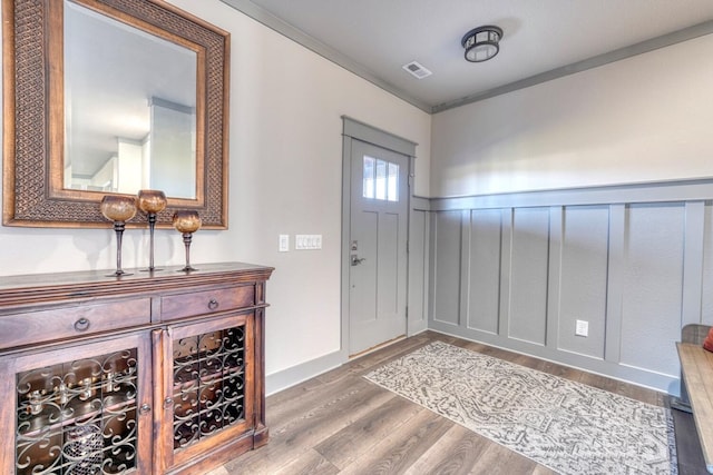 entrance foyer with hardwood / wood-style flooring and ornamental molding