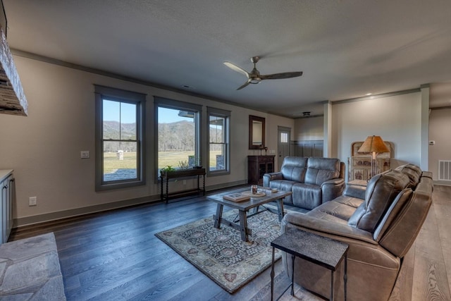 living room featuring hardwood / wood-style flooring, ceiling fan, ornamental molding, a textured ceiling, and a mountain view