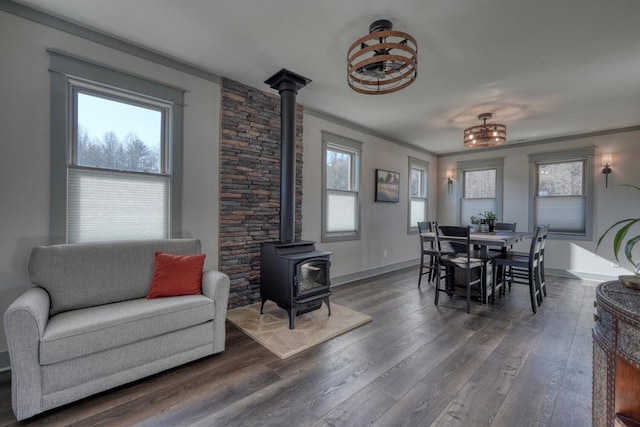 dining room with dark hardwood / wood-style flooring, ornamental molding, and a wood stove