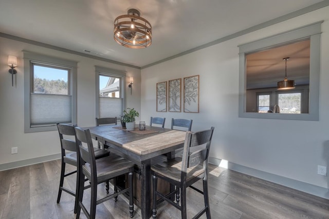 dining area with dark hardwood / wood-style flooring and crown molding