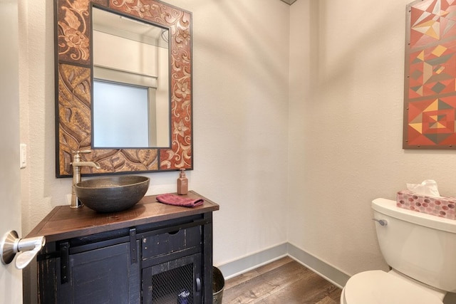 bathroom featuring vanity, hardwood / wood-style floors, and toilet