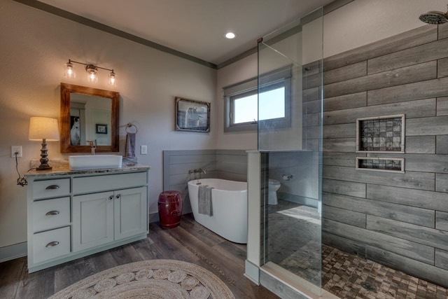 bathroom featuring independent shower and bath, vanity, hardwood / wood-style flooring, and ornamental molding