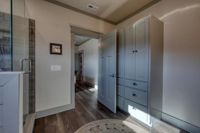 bathroom featuring hardwood / wood-style flooring, crown molding, and a shower with door