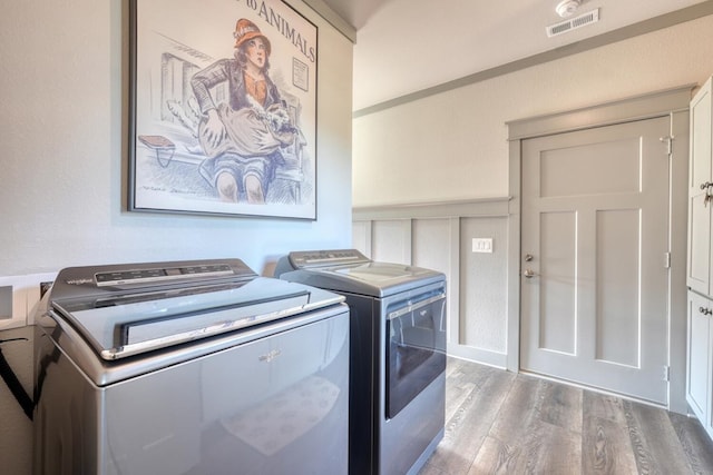 laundry room with separate washer and dryer and wood-type flooring