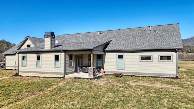 rear view of house with a patio and a yard