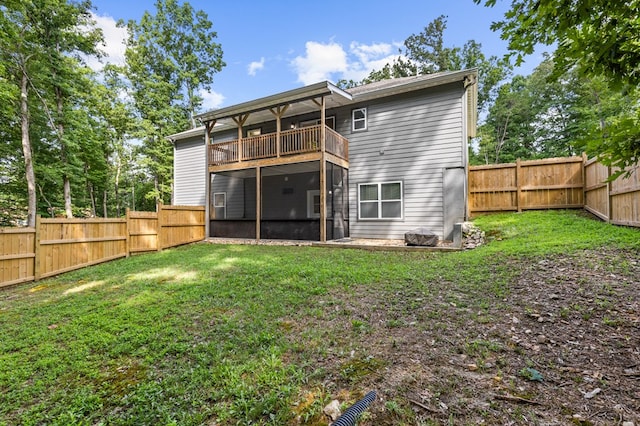 back of house with a gate, a sunroom, a fenced backyard, a balcony, and a yard