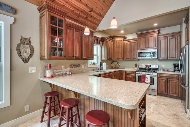 249 Whispering Pine Trl, Murphy, NC 28906 - kitchen featuring appliances with stainless steel finishes, a peninsula, vaulted ceiling, light countertops, and a kitchen bar