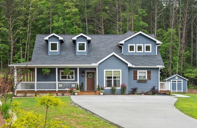 196 Autumn Ridge Dr, Mineral Bluff, GA 30559 - view of front facade featuring covered porch, roof with shingles, a wooded view, a front yard, and a shed