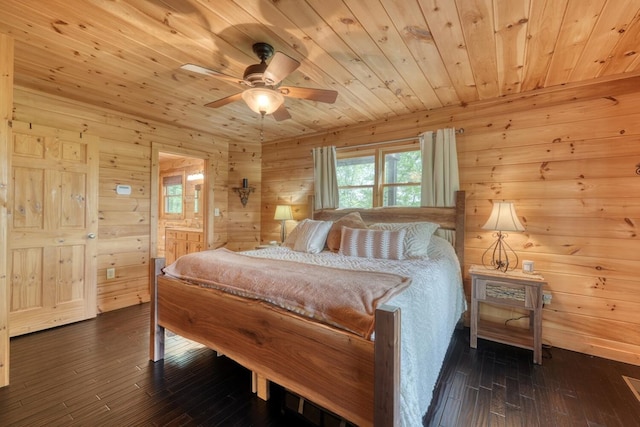 bedroom with wooden walls, dark wood-style flooring, ensuite bath, a ceiling fan, and wood ceiling