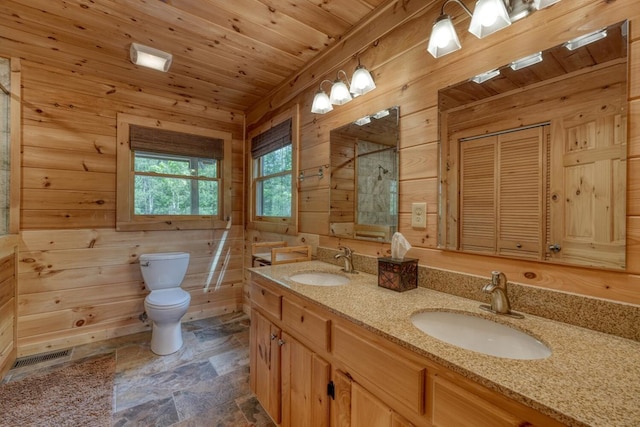 bathroom with toilet, wood walls, and a sink