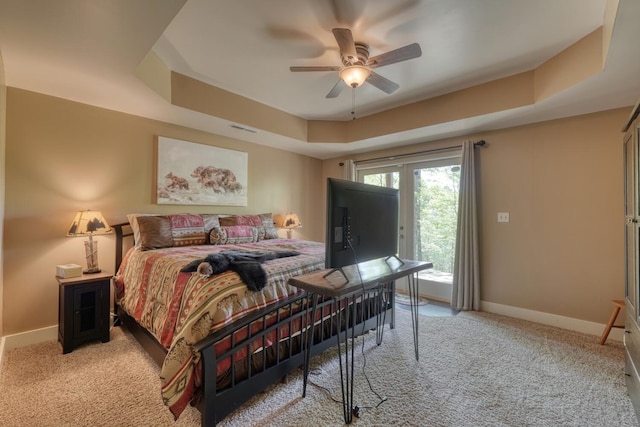 bedroom featuring access to exterior, visible vents, a raised ceiling, baseboards, and light carpet