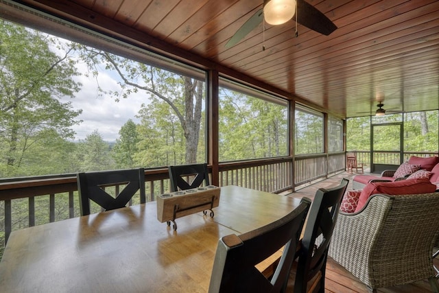 sunroom with a ceiling fan, outdoor dining area, and an outdoor living space