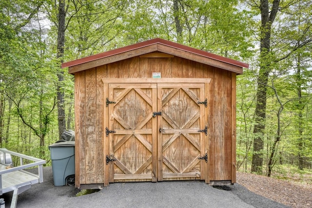 view of shed featuring a view of trees