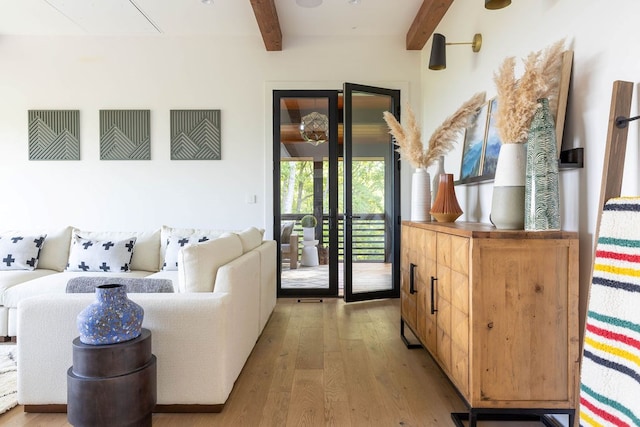 living room with beamed ceiling and light hardwood / wood-style floors