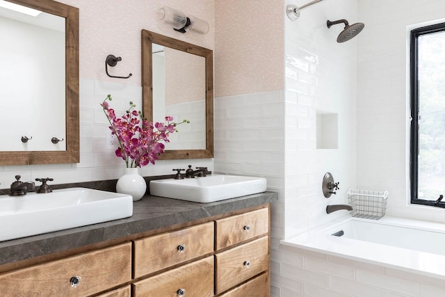 bathroom featuring tiled shower / bath combo, double sink vanity, and tile walls