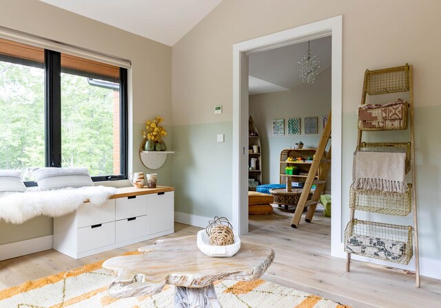 living area featuring vaulted ceiling and light hardwood / wood-style flooring